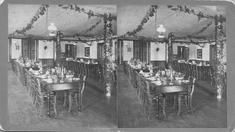 SA0440 - Tables and chairs set for dining with garlands strung above. Associated with the Church Family. Identified on the back.